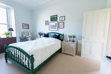 Design ideas for a mid-sized beach style master bedroom in Edinburgh with blue walls, carpet, no fireplace and beige floor.
