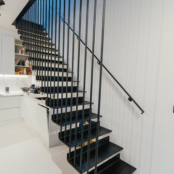 Blackened mild steel on side spine type staircases with metal railing