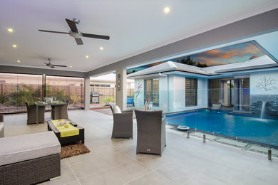 Photo of an expansive contemporary side yard verandah in Cairns with tile and a roof extension.
