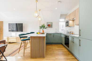 Esempio di una cucina design di medie dimensioni con ante lisce, ante blu, pavimento in legno massello medio, nessuna isola, pavimento marrone e top bianco