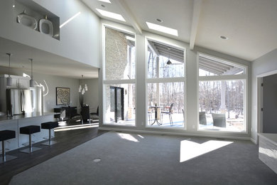 Example of a mid-sized trendy u-shaped dark wood floor eat-in kitchen design in Other with a farmhouse sink, flat-panel cabinets, white cabinets, solid surface countertops, white backsplash, stone slab backsplash, stainless steel appliances and an island