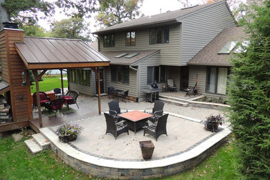 Large traditional backyard patio in Other with a fire feature and no cover.