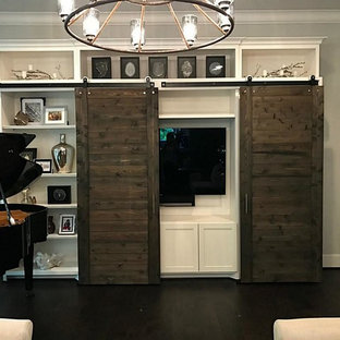 This is an example of a large mediterranean formal open plan living room in Houston with beige walls, laminate floors, a concealed tv and brown floors.