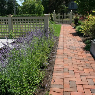 Aménagement d'un jardin à la française latéral victorien de taille moyenne et l'été avec une entrée ou une allée de jardin, une exposition ensoleillée et des pavés en brique.