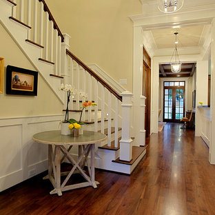 Mid-sized elegant dark wood floor entryway photo in Houston with yellow walls and a glass front door