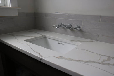 Design ideas for a transitional bathroom in New York with gray tile, porcelain tile, porcelain floors, engineered quartz benchtops and grey floor.