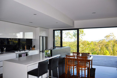 Design ideas for a contemporary kitchen in Brisbane with black splashback and with island.