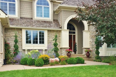 This is an example of a mid-sized traditional partial sun front yard concrete paver landscaping in Minneapolis.