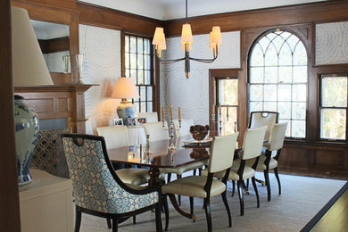 This is an example of a mid-sized traditional separate dining room in Chicago with grey walls, medium hardwood floors, a standard fireplace, a wood fireplace surround and brown floor.
