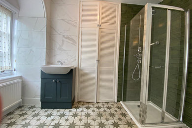 Design ideas for a large victorian family bathroom in Surrey with shaker cabinets, green cabinets, a corner shower, a one-piece toilet, green tiles, porcelain tiles, white walls, porcelain flooring, a built-in sink, engineered stone worktops, green floors, a hinged door, white worktops, a single sink and a freestanding vanity unit.