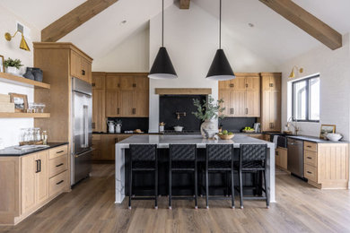 Eat-in kitchen - cottage eat-in kitchen idea in San Diego with medium tone wood cabinets, marble countertops, an island and black countertops