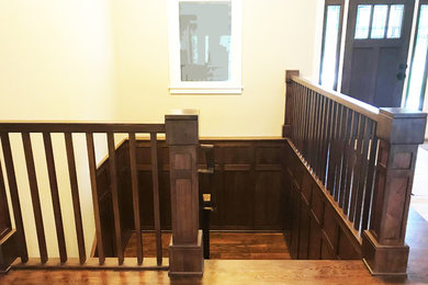 Example of an arts and crafts wooden u-shaped wood railing staircase design in Chicago with wooden risers
