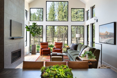 Imagen de salón abierto y abovedado contemporáneo grande con suelo de madera clara, todas las chimeneas, marco de chimenea de baldosas y/o azulejos y televisor colgado en la pared