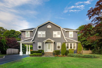 Example of a large classic black two-story vinyl and clapboard house exterior design in Other with a gambrel roof, a shingle roof and a black roof