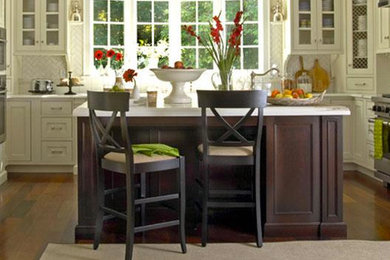 Mid-sized elegant u-shaped medium tone wood floor open concept kitchen photo in Toronto with a farmhouse sink, shaker cabinets, white cabinets, quartzite countertops, white backsplash, porcelain backsplash, stainless steel appliances and an island