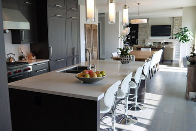 Example of a large trendy l-shaped light wood floor open concept kitchen design in Vancouver with an undermount sink, shaker cabinets, dark wood cabinets, quartz countertops, white backsplash, stone slab backsplash, stainless steel appliances and an island