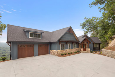 Inspiration for a large rustic blue two-story wood and board and batten house exterior remodel in Other with a shingle roof and a gray roof