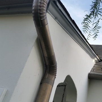 Bonderized Steel, 5 inch Half Round Seamless Gutters with Round Downspouts.