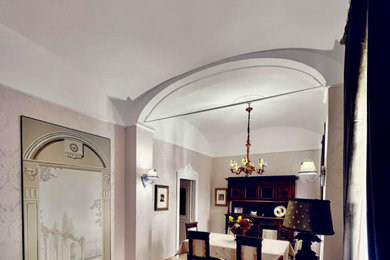 Foto di un'ampia sala da pranzo aperta verso il soggiorno tradizionale con pareti beige, pavimento con piastrelle in ceramica, pavimento beige, soffitto a volta e carta da parati