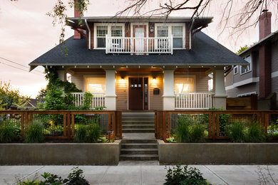 Photo of a traditional two-storey beige house exterior in Portland with a gable roof and a shingle roof.