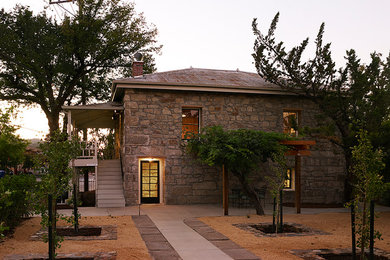 Example of a large country beige two-story stone house exterior design in San Francisco with a hip roof and a metal roof
