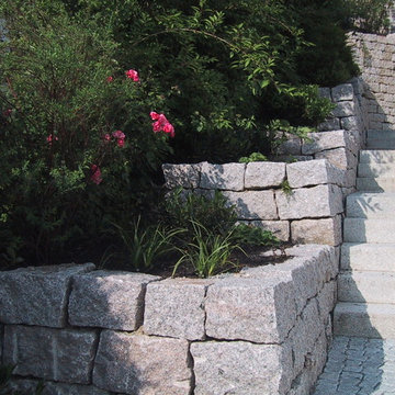 Hausgarten in Hanglage mit Natursteinmauern