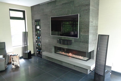 Photo of a mid-sized contemporary formal enclosed living room in Minneapolis with grey walls, porcelain floors, a corner fireplace, a tile fireplace surround and a wall-mounted tv.