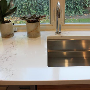 Large modern u-shaped kitchen pantry in Seattle with an undermount sink, flat-panel cabinets, orange cabinets, granite benchtops, white splashback, stainless steel appliances, porcelain floors, with island, white floor and beige benchtop.