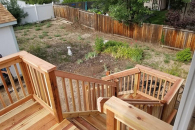 Deck - traditional backyard wood railing deck idea in Other