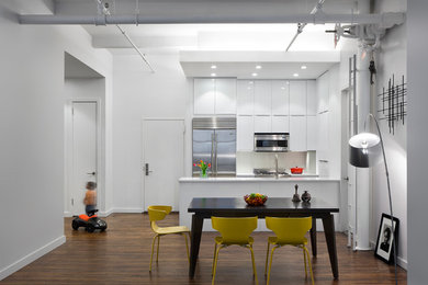 Inspiration for a large contemporary galley dark wood floor eat-in kitchen remodel in New York with an undermount sink, flat-panel cabinets, white cabinets, quartz countertops, white backsplash, glass tile backsplash, stainless steel appliances and an island