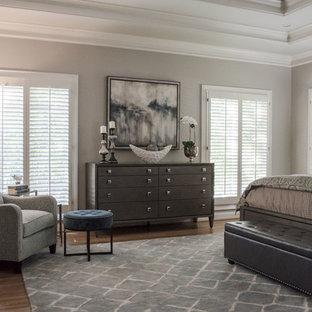 Inspiration pour une grande chambre parentale traditionnelle avec un mur gris, un sol en bois brun, aucune cheminée et un sol orange.