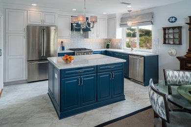 This is an example of a mid-sized traditional l-shaped eat-in kitchen in Orange County with an undermount sink, raised-panel cabinets, blue cabinets, marble benchtops, grey splashback, mosaic tile splashback, stainless steel appliances, porcelain floors, with island and white floor.