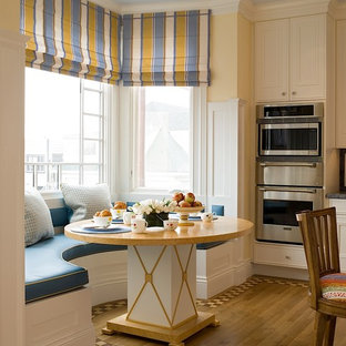 Große Klassische Wohnküche mit gelber Wandfarbe, braunem Holzboden und braunem Boden in San Francisco