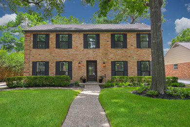 Inspiration for a mid-sized timeless two-story brick house exterior remodel in Houston with a shingle roof