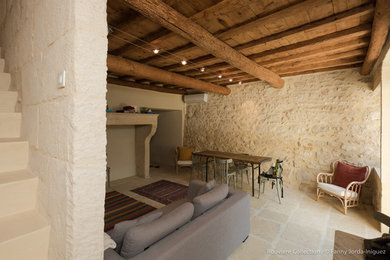 Inspiration pour une salle de séjour traditionnelle avec un mur beige, sol en béton ciré, un manteau de cheminée en pierre, un sol beige et un plafond en bois.