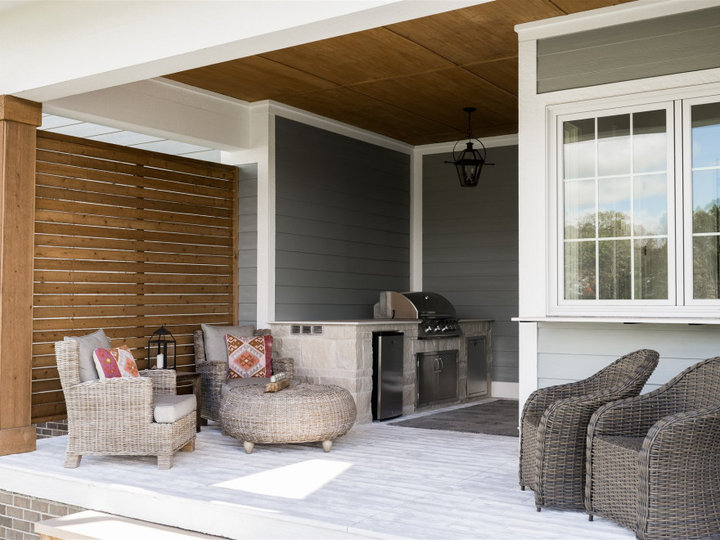 An example of a mid-sized contemporary front porch design with a roof extension.