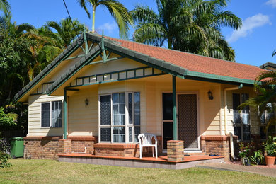 Photo of a mid-sized traditional one-storey beige exterior in Townsville with mixed siding.
