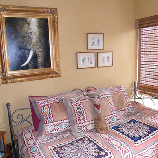 Ispirazione per una piccola camera degli ospiti etnica con pareti gialle e pavimento in bambù