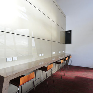 This is an example of a large modern study in Other with beige walls, carpet, pink floors and a built-in desk.