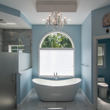 Traditional master bath utilizing frosted and clear glass to allow for needed pr
