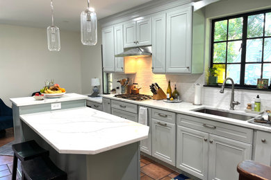 Small elegant terra-cotta tile and brown floor enclosed kitchen photo in New York with an undermount sink, beaded inset cabinets, green cabinets, quartzite countertops, white backsplash, porcelain backsplash, stainless steel appliances, an island and white countertops