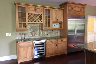 Inspiration for a mid-sized timeless dark wood floor and brown floor enclosed kitchen remodel in Wilmington with an undermount sink, beaded inset cabinets, light wood cabinets, granite countertops, beige backsplash, mosaic tile backsplash, stainless steel appliances and an island