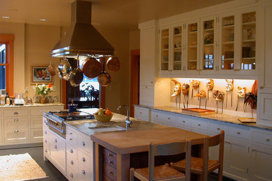 Enclosed kitchen - mid-sized craftsman l-shaped linoleum floor enclosed kitchen idea in Seattle with a farmhouse sink, shaker cabinets, white cabinets, beige backsplash, stone slab backsplash, stainless steel appliances, an island and granite countertops