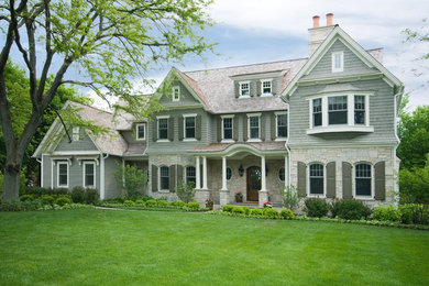 This is an example of an expansive traditional three-storey beige house exterior in Chicago with mixed siding, a hip roof and a shingle roof.