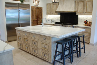 Inspiration for a large traditional eat-in kitchen in Austin with marble benchtops, stainless steel appliances, terra-cotta floors, with island, a single-bowl sink, raised-panel cabinets, distressed cabinets, white splashback and stone tile splashback.