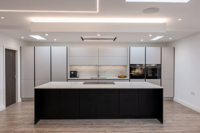 Imagen de cocina comedor lineal y gris y blanca moderna de tamaño medio con una isla