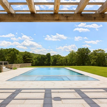 glass tile swimming pool + spa with perimeter overflow + granite decking