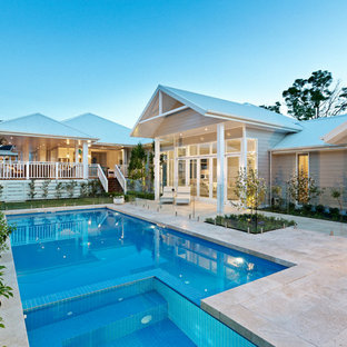 Réalisation d'un grand jardin arrière marin avec une exposition ensoleillée et des pavés en pierre naturelle.