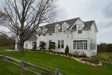 Large traditional white two-story wood gable roof idea in Cleveland