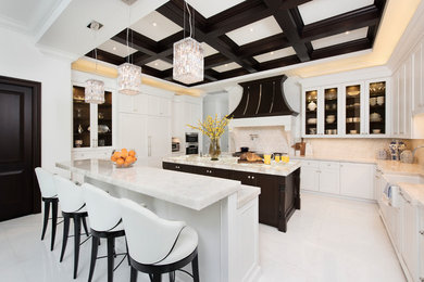 Transitional u-shaped kitchen in Miami with a farmhouse sink, glass-front cabinets, white cabinets, beige splashback, panelled appliances, multiple islands, white floor, white benchtop and quartzite benchtops.